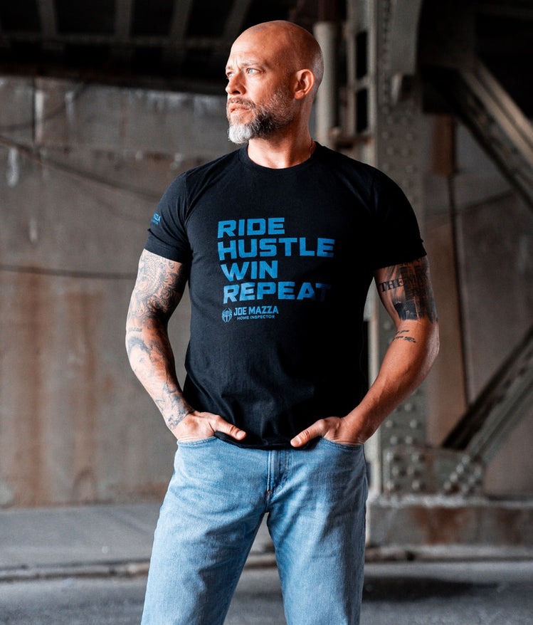 Joe Mazza wearing a Ride Hustle Repeat and standing in an industrial site