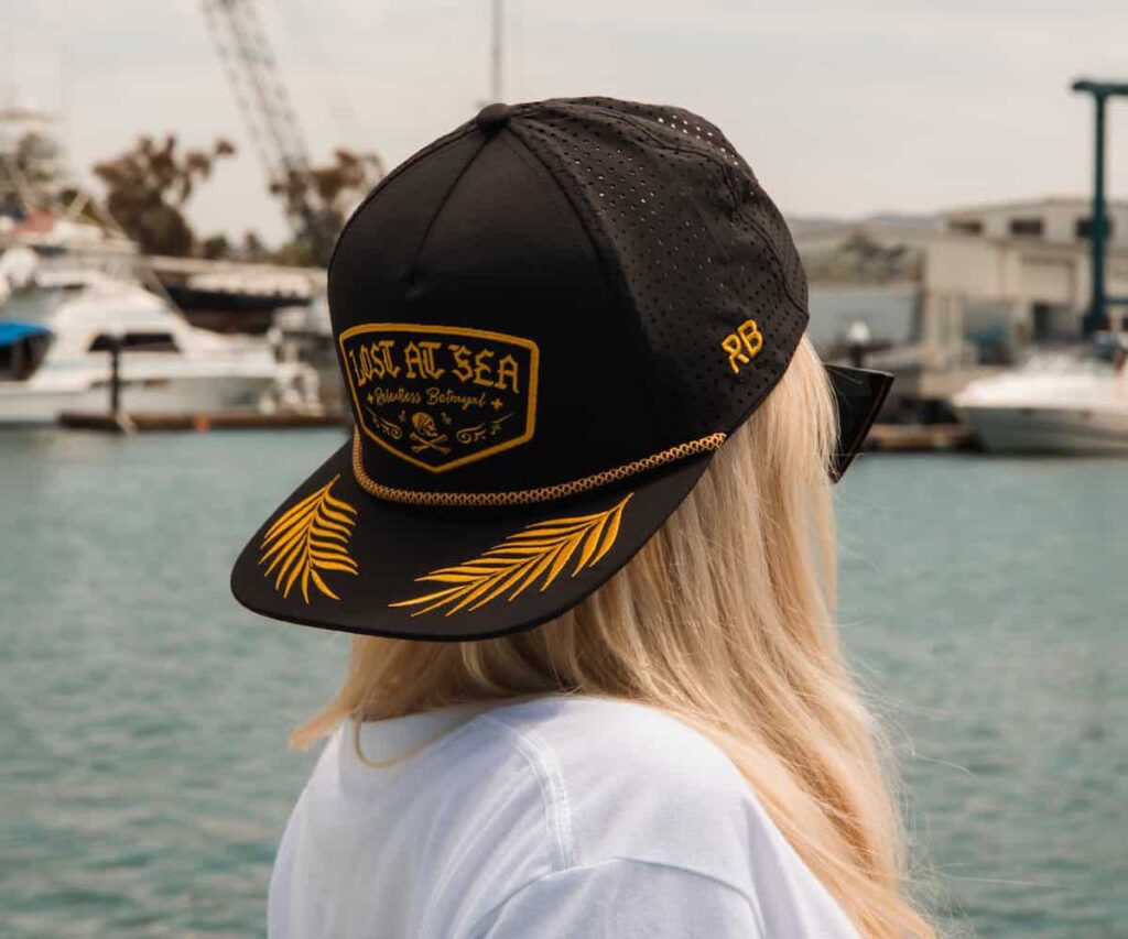 Lost at sea hat backwards on woman with blond hair looking away